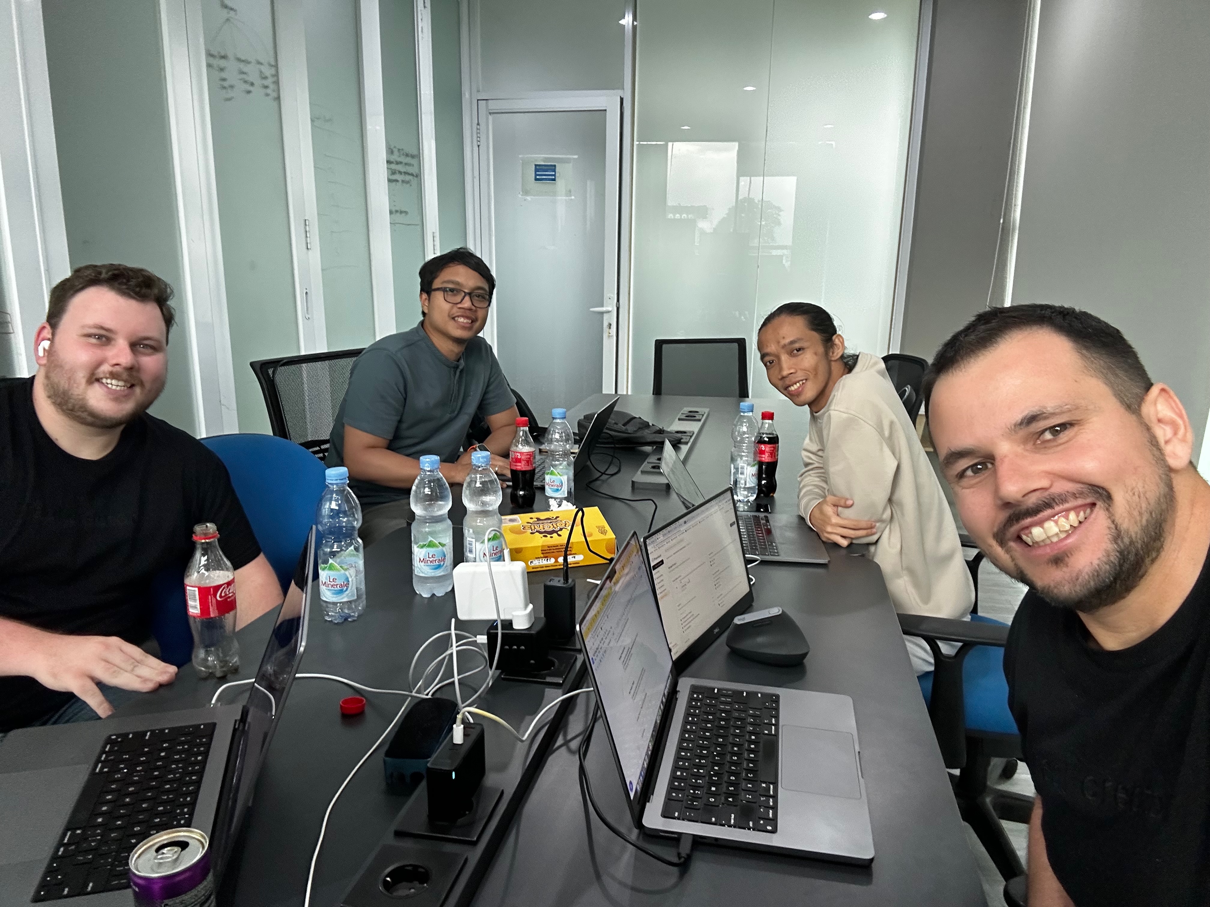 Four of the Thinkers/Builders team around a desk of laptops